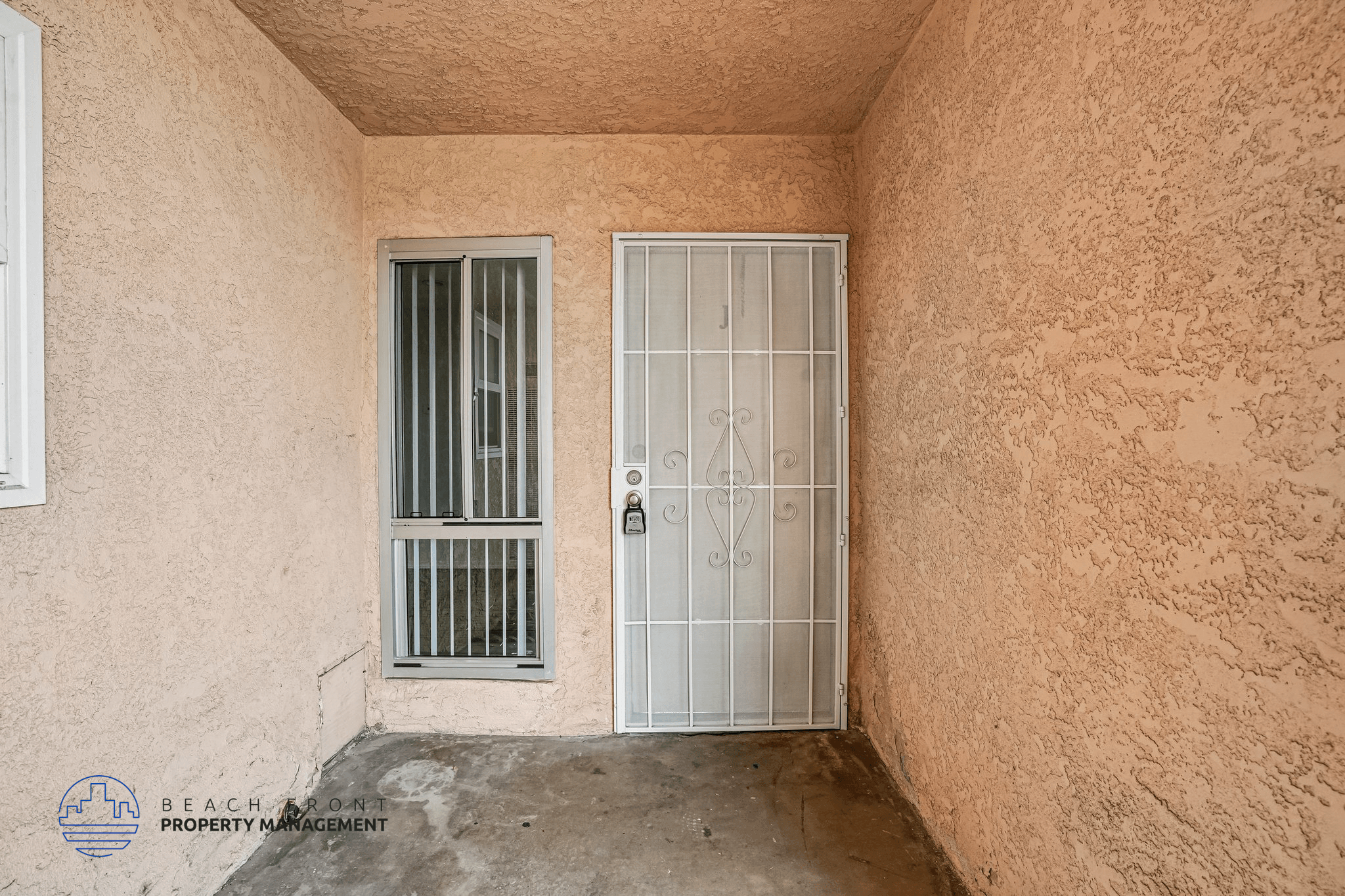 A room with a closed white door and a window with bars.